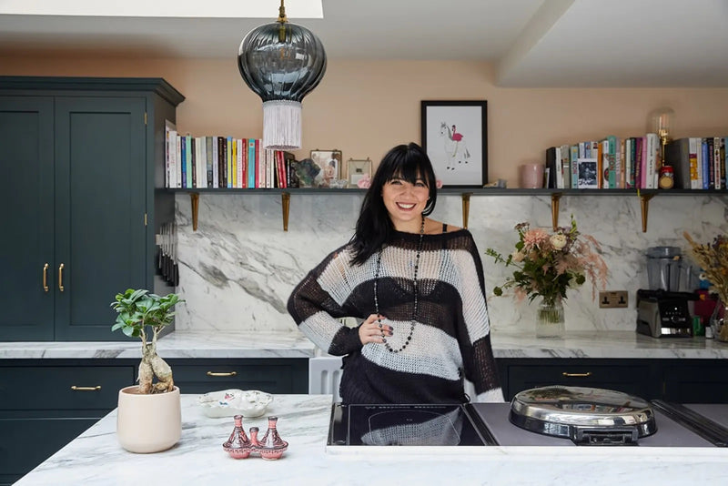 Daisy Lowe standing in her kitchen decorated in Lick Pink 02 paint shade