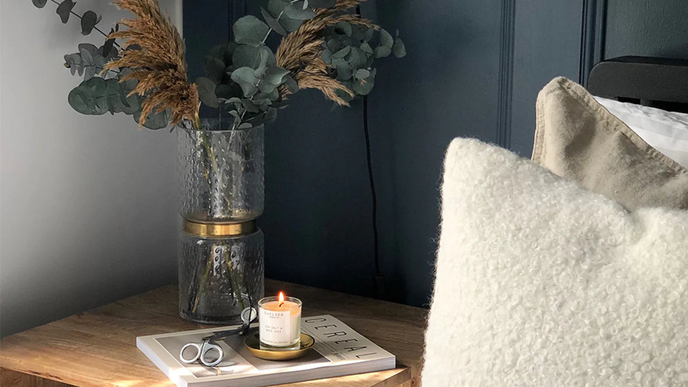 Small dark bedroom with bouclé cushion