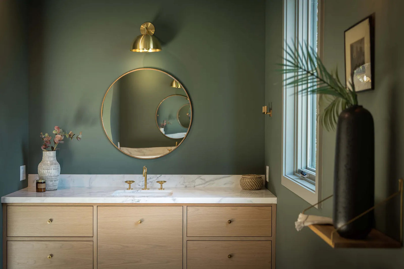 Bathroom with green painted walls and gold fixtures via Unsplash 
