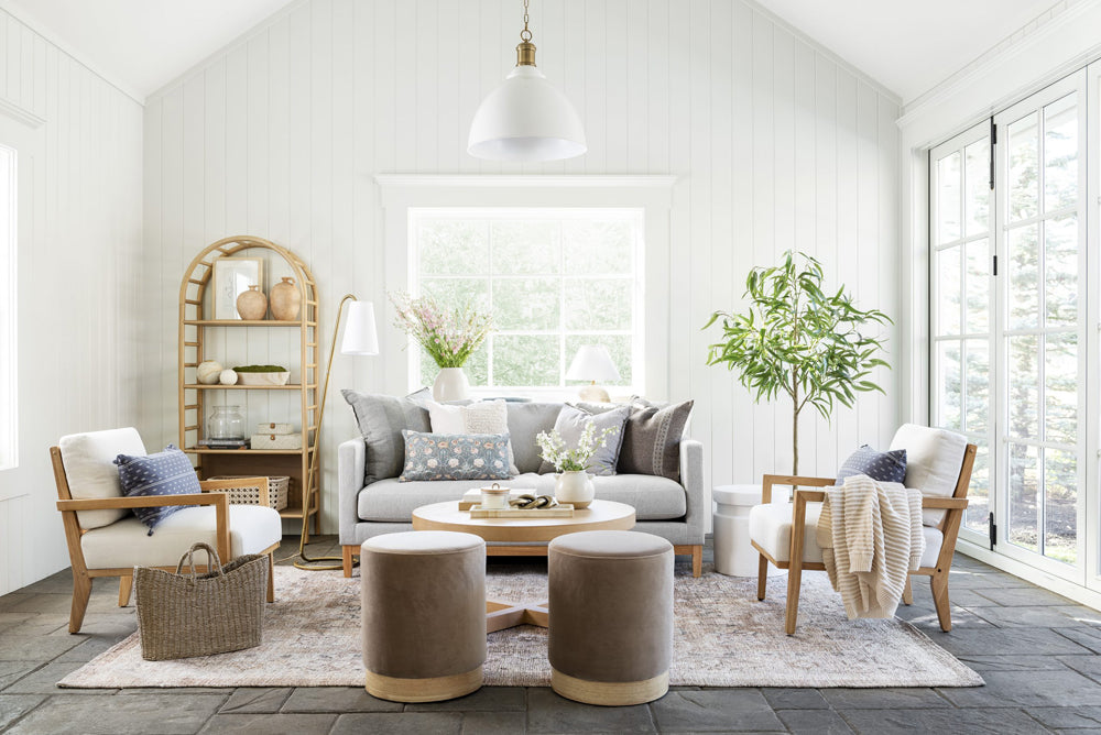 Modern farmhouse living room space with a grey sofa and large windows