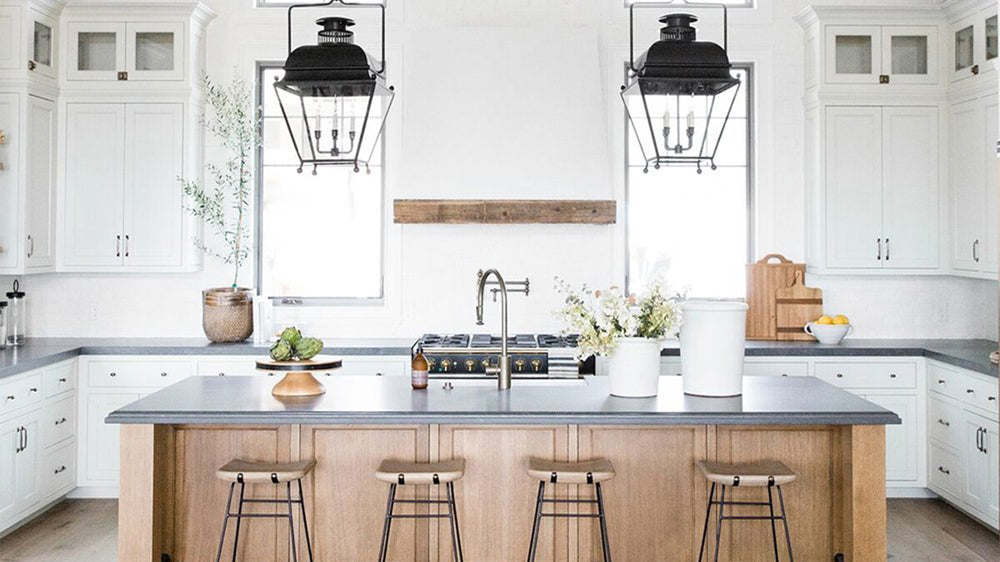 Modern farmhouse kitchen with black pendant lights and an oversized kitchen island via Studio McGee